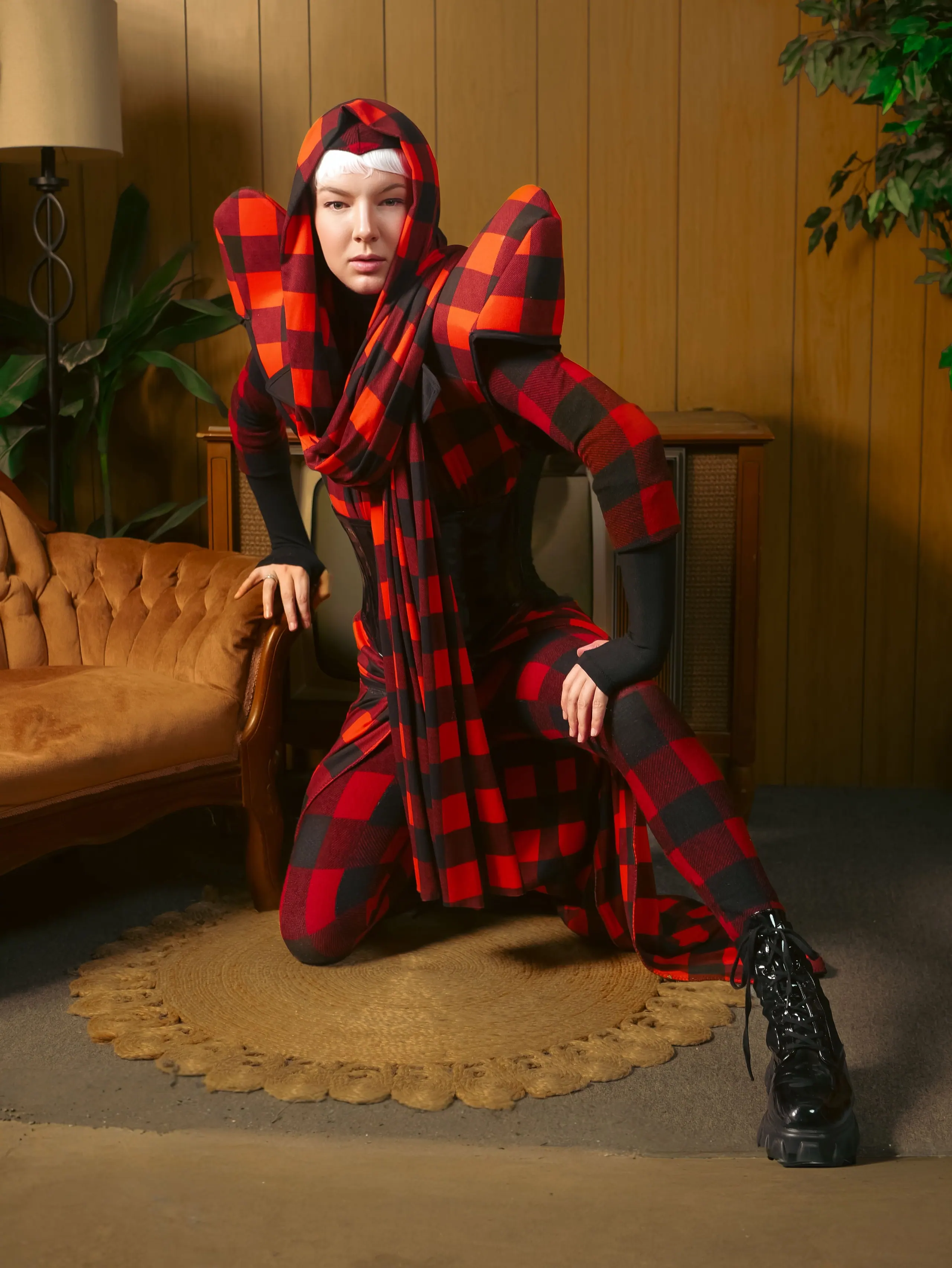 The buffalo check look kneeling on a round rug in a wood-panelled room